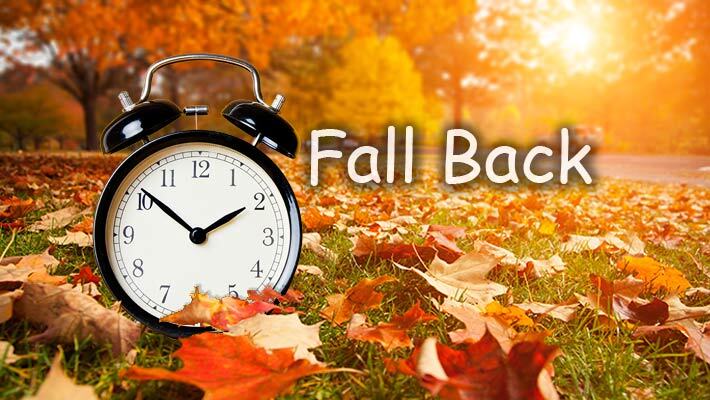 A clock surrounded by leaves with the text, Fall Back. 